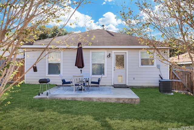 rear view of property featuring cooling unit, a patio area, and a lawn