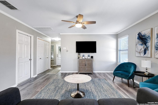 living room featuring hardwood / wood-style flooring, ceiling fan, and ornamental molding