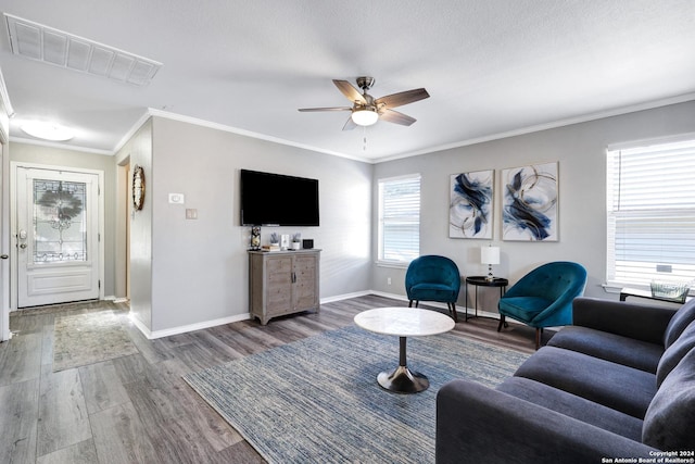 living room with hardwood / wood-style flooring, plenty of natural light, crown molding, and ceiling fan