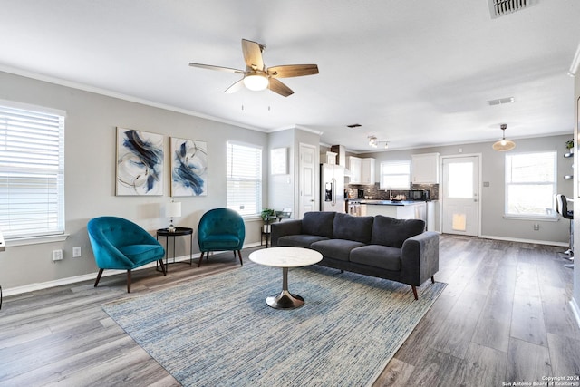 living room with plenty of natural light, ceiling fan, and crown molding