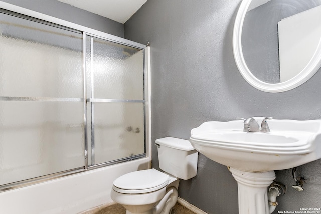 bathroom with shower / bath combination with glass door and toilet