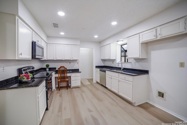 kitchen with sink, white cabinets, light wood-type flooring, and appliances with stainless steel finishes