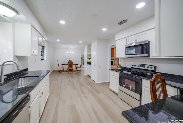 kitchen with dark stone counters, stainless steel appliances, sink, light hardwood / wood-style floors, and white cabinetry