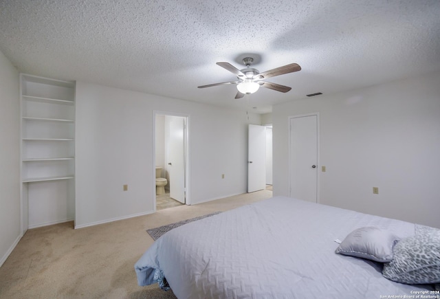 bedroom with connected bathroom, ceiling fan, light colored carpet, and a textured ceiling