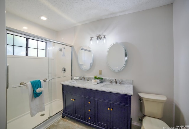 bathroom with vanity, a shower with shower door, a textured ceiling, and toilet