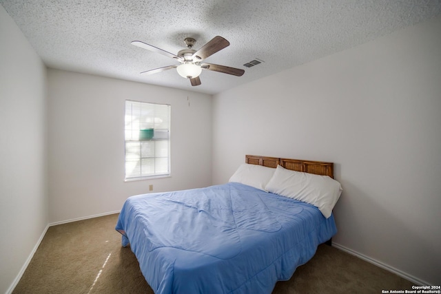 bedroom featuring ceiling fan, a textured ceiling, and dark colored carpet