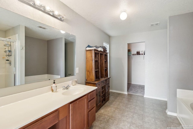 bathroom with vanity, separate shower and tub, and a textured ceiling