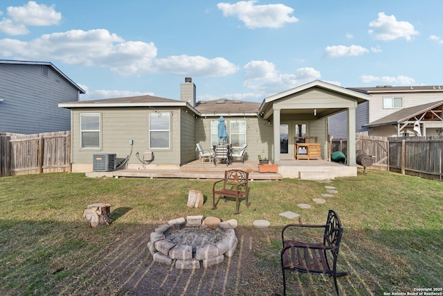 back of house featuring a wooden deck, a yard, central AC unit, and an outdoor fire pit