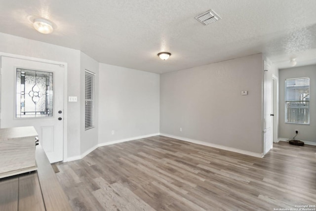 entrance foyer featuring light hardwood / wood-style floors and a textured ceiling