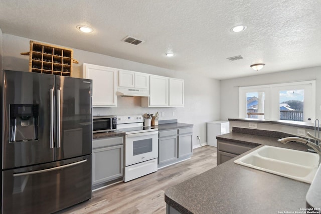 kitchen featuring gray cabinetry, a textured ceiling, stainless steel appliances, sink, and white cabinets