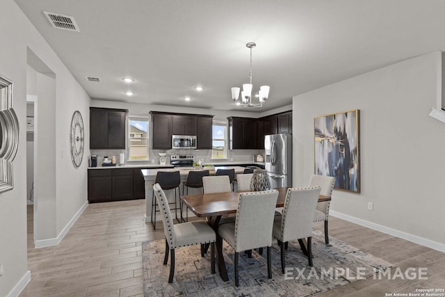 dining area featuring light hardwood / wood-style floors and an inviting chandelier