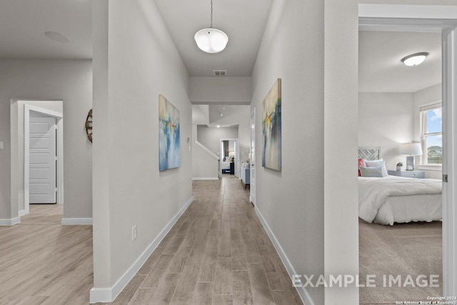 hallway with light hardwood / wood-style floors