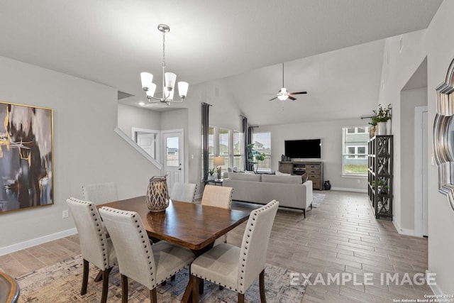 dining area featuring ceiling fan with notable chandelier and lofted ceiling