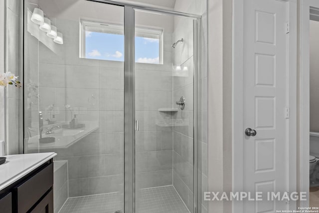 bathroom with a shower with door, vanity, and toilet