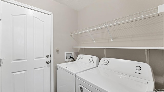 washroom with washing machine and dryer and a textured ceiling