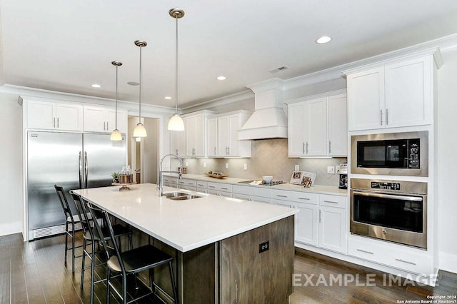 kitchen with built in appliances, white cabinets, and sink