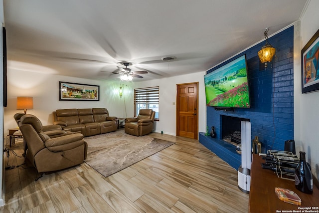 living room with ceiling fan, wood-type flooring, and a fireplace