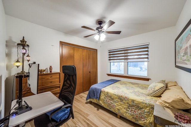 bedroom featuring ceiling fan, light wood-type flooring, and a closet