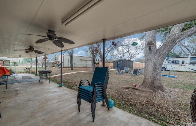 view of patio / terrace featuring a playground, ceiling fan, and a storage unit