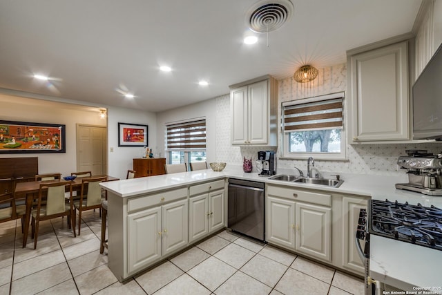 kitchen with sink, appliances with stainless steel finishes, tasteful backsplash, light tile patterned flooring, and kitchen peninsula