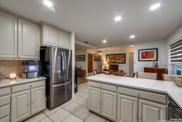 kitchen featuring backsplash, white cabinets, stainless steel appliances, and light tile patterned floors