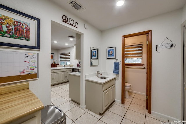 bathroom featuring tile patterned flooring, a healthy amount of sunlight, and toilet