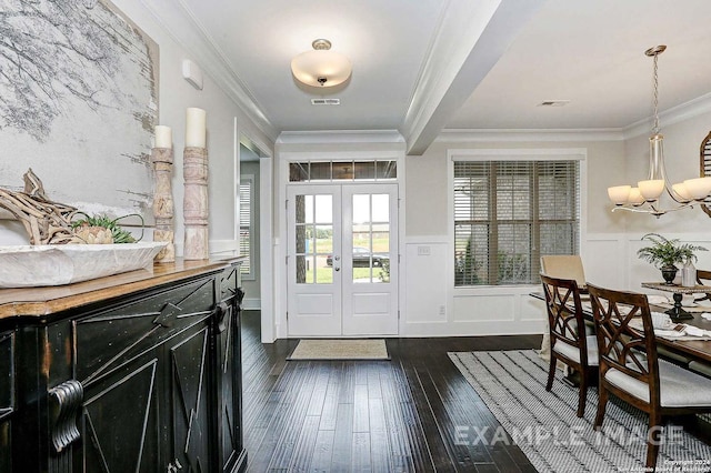 foyer with crown molding, french doors, dark hardwood / wood-style floors, and an inviting chandelier