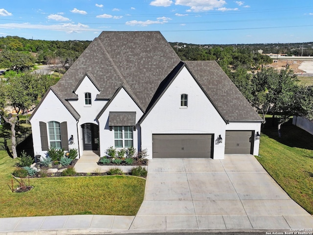 french provincial home featuring a front lawn and a garage