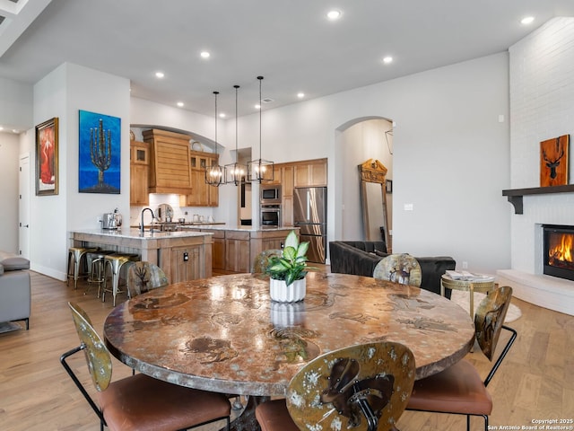 dining area featuring sink, a fireplace, and light hardwood / wood-style floors