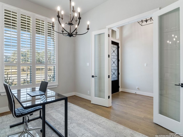 office space featuring french doors, an inviting chandelier, and hardwood / wood-style flooring