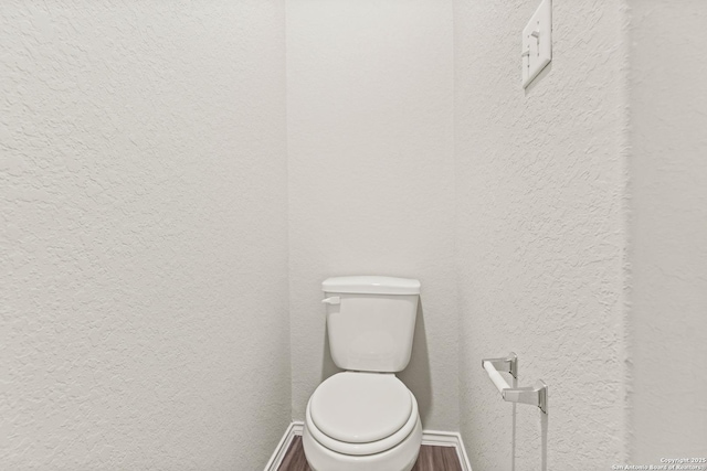 bathroom with wood-type flooring and toilet