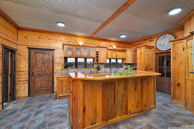 kitchen featuring a center island, wooden walls, and sink