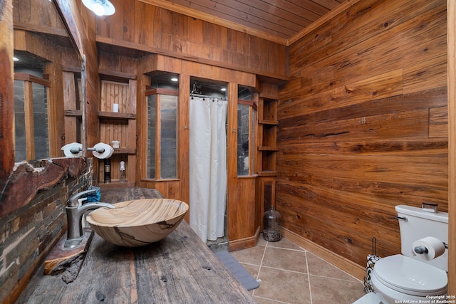 bathroom with wood walls, wooden ceiling, sink, tile patterned flooring, and curtained shower