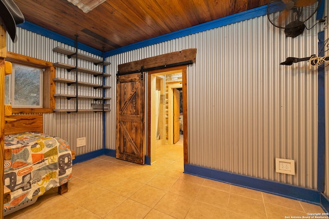 interior space with a barn door, light tile patterned floors, and wood ceiling