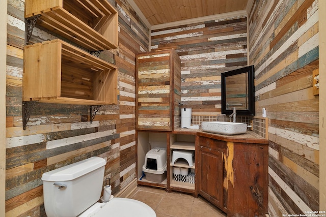 bathroom with wood ceiling, vanity, tile patterned flooring, toilet, and wood walls