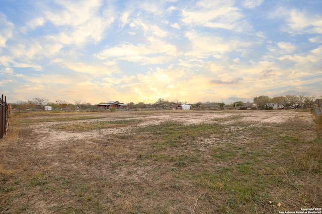 yard at dusk featuring a rural view