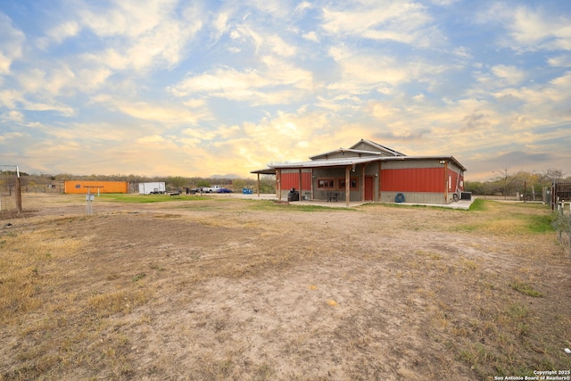 yard at dusk featuring a rural view