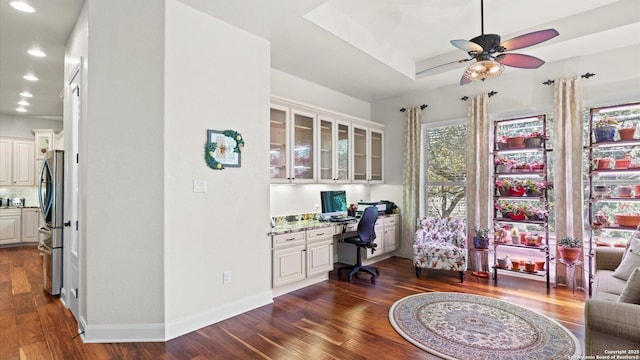 office area with ceiling fan, dark hardwood / wood-style flooring, and built in desk