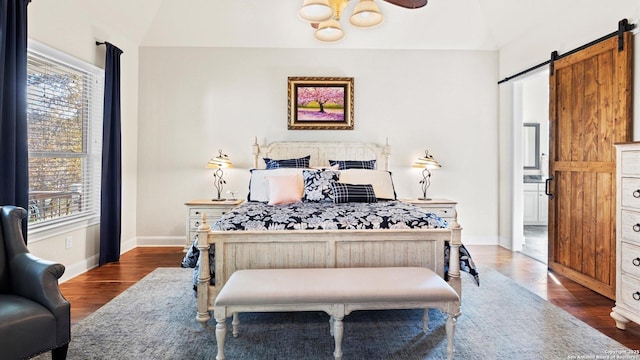 bedroom featuring dark hardwood / wood-style flooring, a barn door, ceiling fan, and lofted ceiling