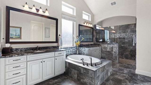 bathroom with plus walk in shower, vanity, and vaulted ceiling