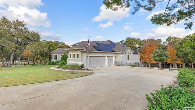 view of front of property with a front lawn and solar panels