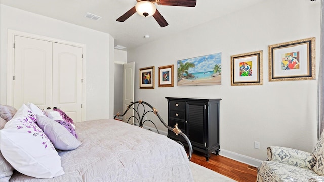 bedroom with hardwood / wood-style floors, ceiling fan, and a closet