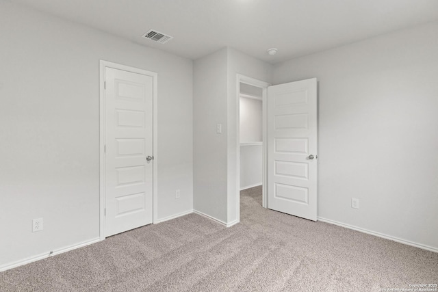 unfurnished bedroom with light carpet and a closet