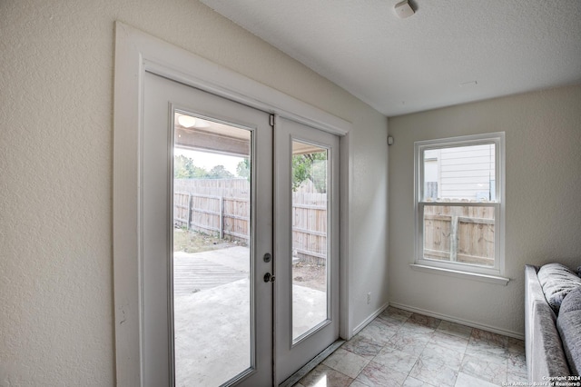 entryway with radiator, a wealth of natural light, french doors, and a textured ceiling