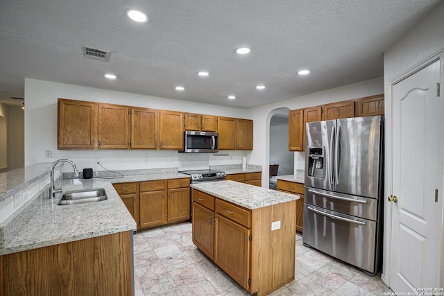 kitchen featuring a textured ceiling, kitchen peninsula, sink, and appliances with stainless steel finishes