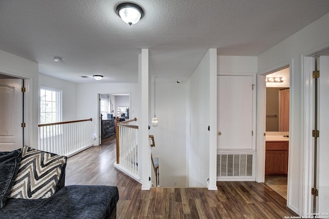 hall featuring a textured ceiling and dark wood-type flooring