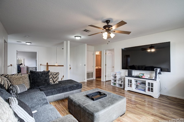 living room with ceiling fan, wood-type flooring, and a textured ceiling