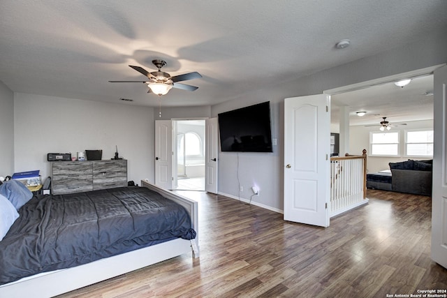 bedroom featuring ceiling fan, wood-type flooring, and a textured ceiling