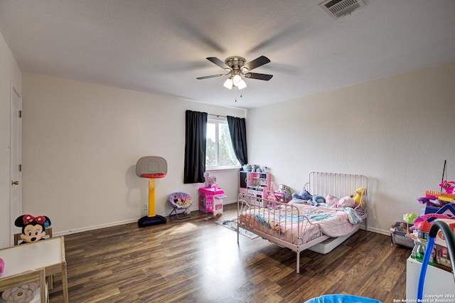 bedroom featuring ceiling fan, dark hardwood / wood-style flooring, and a textured ceiling