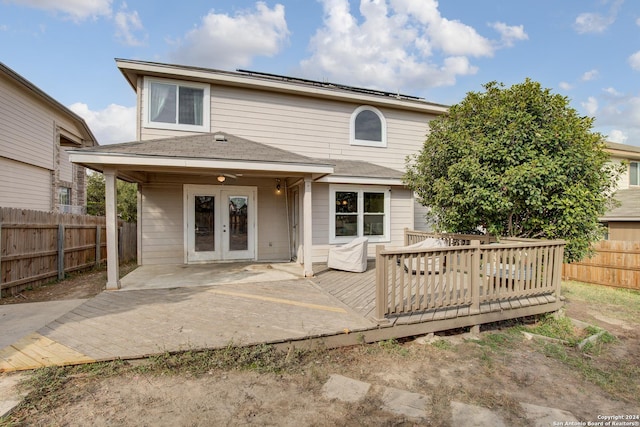 back of house with solar panels, french doors, and a deck